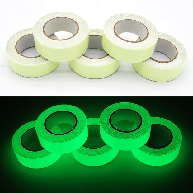 Glow in the dark sticker tape roll glowing in low light, used for home decor, stairs, and DIY crafts.

