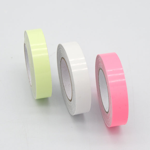 Glow in the dark sticker tape roll glowing in low light, used for home decor, stairs, and DIY crafts.

